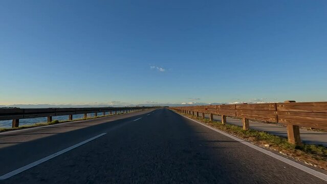 Camera Car on Road from Grado to Aquilea in Friuli Venezia Giulia Italy - Driving on a road over a lagoon in Adriatic sea Europe