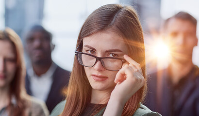 Portrait of a young serious business woman with colleagues