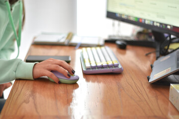 young woman using a lilac-colored mouse and keyboard