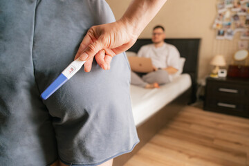 woman holding positive pregnancy test surprise for husband