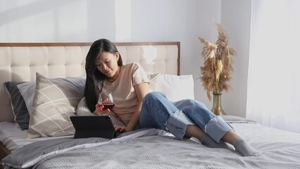 Happy beautiful woman in casual clothes talking on video call on digital tablet lying on the bed. Celebration valentines day dating on quarantine concept - Powered by Adobe