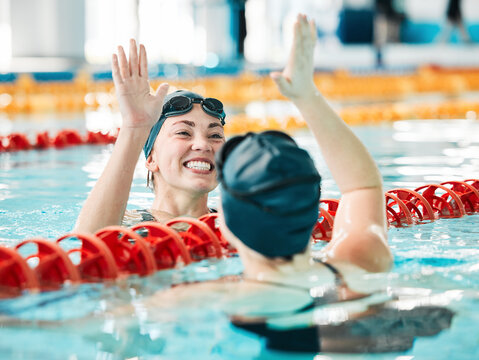 Fitness, swimmer and women with high five, celebration and achievement with workout, wellness and winning. Exercise, winner or champion in a pool, celebration or support with success, sports or smile