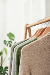 Multicolored handknitted sweaters on hangers - 638555096