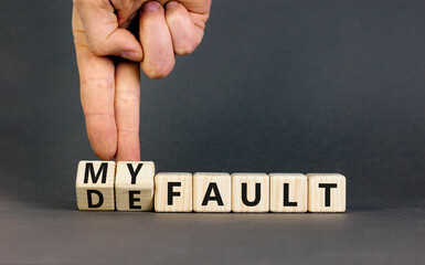 Default is my fault symbol. Concept words Default and My fault on wooden cubes. Beautiful grey table grey background. Businessman hand. Business default is my fault concept. Copy space.