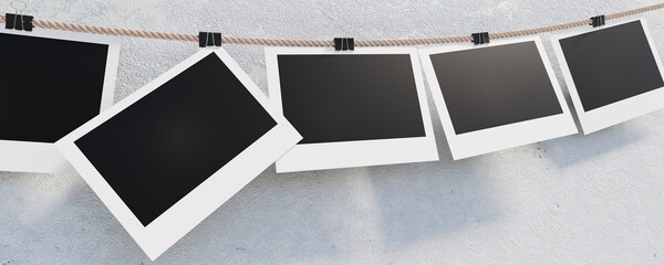 Photo frames hang on a rope secured with stationery clothespins. Empty photo frames 16x9 on a concrete wall for your design. 3D visualization