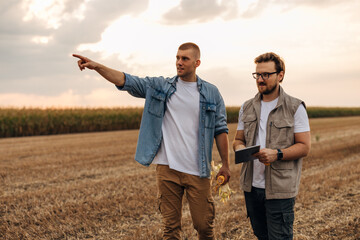 Two Caucasian man monitoring fields with laptop.