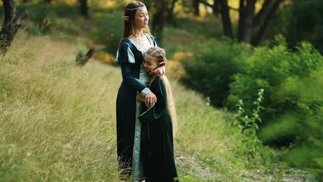 Beautiful elf girls are walking in a green dress in the forest.