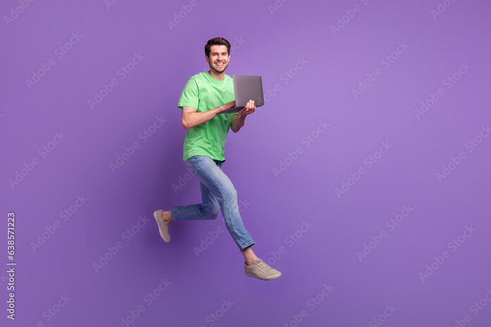 Poster full length body photo of young funny positive man jumping running fast netbook user fast delivery a