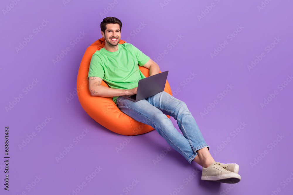 Poster full length photo of young worker guy sitting beanbag freelancer location wifi connection with netbo