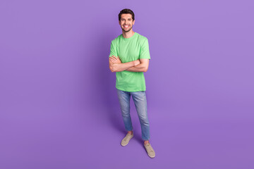 Full body photo of confident optimistic guy folded arms wearing green t-shirt denim levis brand jeans isolated on purple color background