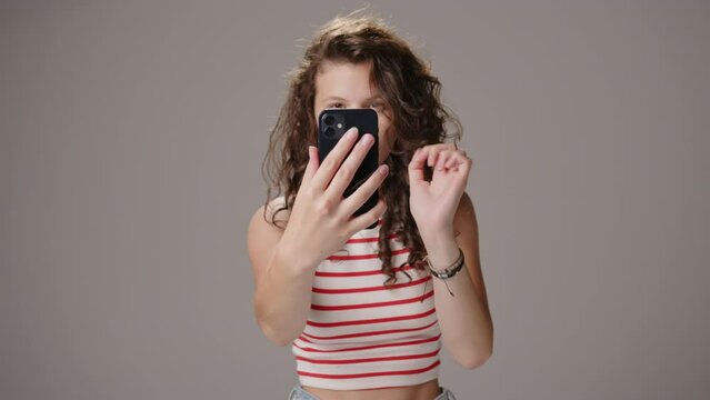 Caucasian teenage girl taking selfies with smartphone, social media trend