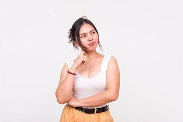 A thoughtful young woman staring to the right and posing with thinking gesture. Isolated on a white background.