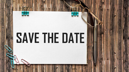 Text save the date on white paper on wooden background ,business concept