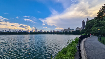 Modern cityscape of New York framed with trees with striking skyscrapers and greenery against a...