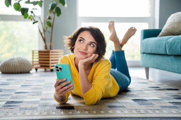 Photo of lady blogger lying floor using gadget thinking about post in instagram modern apartment
