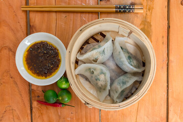 Steamed Prawn and Spring Onion dumplings in dim sum basket served with chili sauce and calamansi....