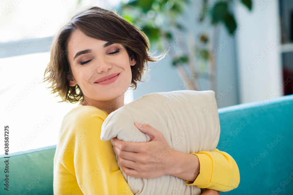 Poster Photo of cheerful adorable cute woman wear yellow clothes hug soft pillow good mood sitting sofa home room indoors