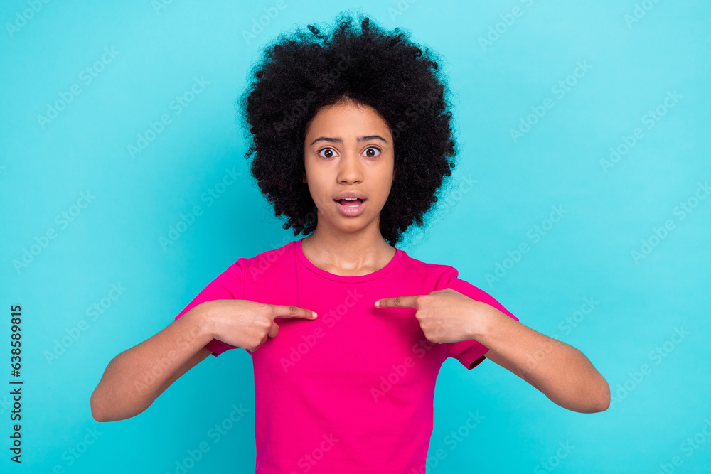 Sticker Portrait of astonished schoolgirl with perming coiffure dressed stylish t-shirt directing at herself isolated on blue color background