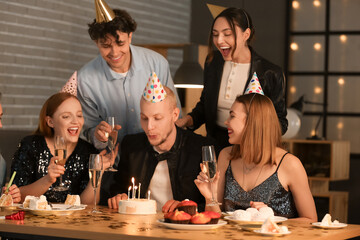 Young man making Birthday wish with his friends at night