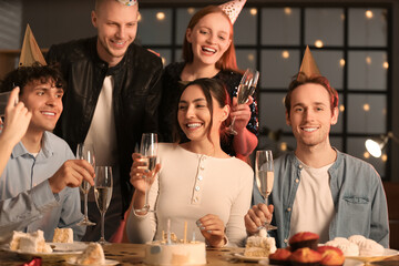 Group of young friends with champagne celebrating Birthday at night