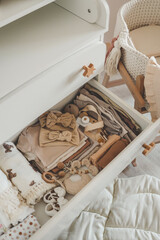 Fototapeta na wymiar Dresser with clothes for a newborn, organizing storage