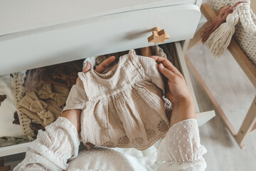 Pregnant woman is getting ready for the maternity hospital, packing baby stuff. pregnant woman preparing and planning baby clothes