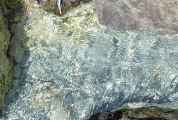 Image of the water surface of the sea in green tones that are clear to see the bottom underwater, texture background, copy space