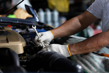 closeup mechanic worker hands checking and fixing a car in garage