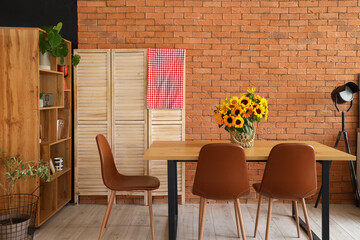 Vase with sunflowers on dining table in modern kitchen