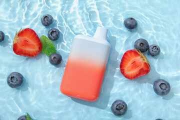 Electronic cigarette with blueberry, strawberry and mint in water on blue background