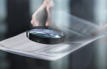 Businessman looking through a magnifying glass to contract