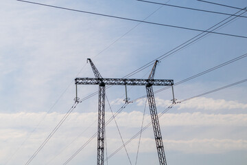 High voltage power line pole, pylon. Power line mast on a blue sky background. Electrification,...