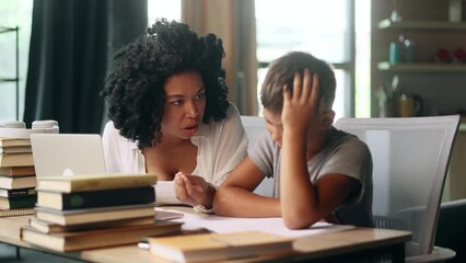Sad primary school boy kid feeling upset while his mother screaming at him because studying at home Angry mad woman mom doing homework together with aggressive indoors Stress education concept
