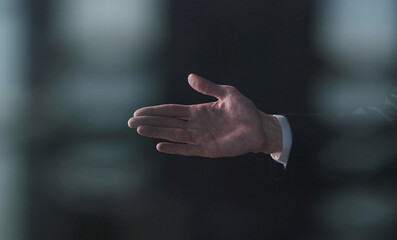 A man's hand is begging for something isolated on a black background. Palm up, close up.