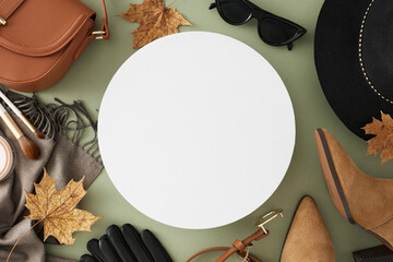 Fashionable autumn outfit idea. Top view of black hat, scarf, boots, eyewear, leather gloves, belt, handbag, cosmetic brushes, dry leaves on pastel green background with promo spot