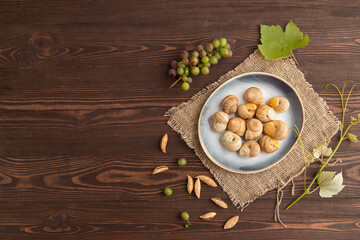 Grape (Burgundy) snails with butter and cheese on brown wooden, top view, copy space.