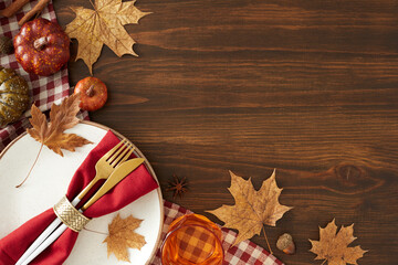 Creating a memorable Thanksgiving table. Top view photo of plate, cutlery, tablecloth, colorful...