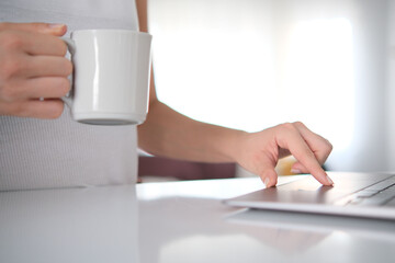 Side view Female holding white coffee mug,using computer.Hands of businesswoman on white background.