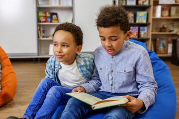 Two African American children are reading book, studying at school and having fun. Back to school.