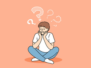 Thoughtful boy sits with sad face and questions above head, thinking about how to spend holidays. Teenager child is trying to remember forgotten information, or to find answers to questions.