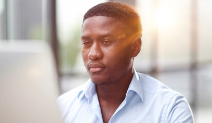 Thoughtful black man in eyeglasses stack with hard task, looking at computer screen, thinking of problem solution