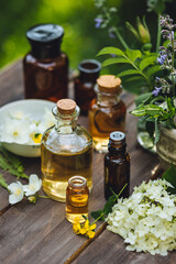 Herbal pure organic essential oil, jasmine, camomile flowers on wooden background. Natural ingredients, apothecary plant-based treatment for relaxation, health care, anti-stress. Aromatherapy