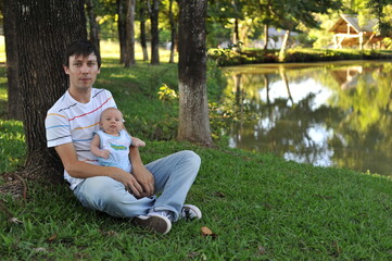 Fototapeta premium pai e filho bebê juntos em parque, amor paterno, primeiro dia dos pais 