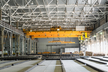 Yellow overhead cranes in engineering plant warehouse. Industrial production hall and warehousing workshop of matal product.
