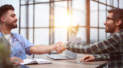 Fototapeta premium Nice doctor shaking hands with the patient
