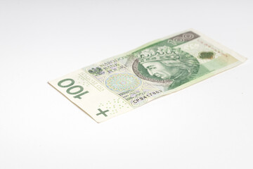 Polish banknote PLN lying on a white background (selective focus)
