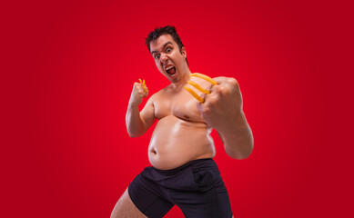 A funny fat man isolated on red background. Obesity and eating disorder. Concept for dietetics and...