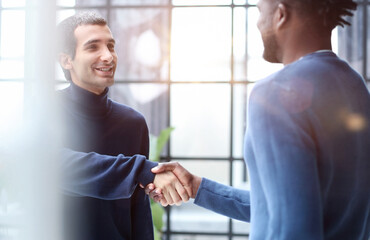 Fototapeta na wymiar Headshot portrait of a smiling businessman offering a handshake. Business concept