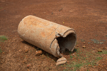 Old broken concrete cement pipe in grass,  Old concrete pipes, Cracked and deteriorated sewer pipes are left or placed on the ground.