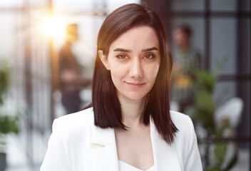 Beautiful young lady in white jacket smiling at camera